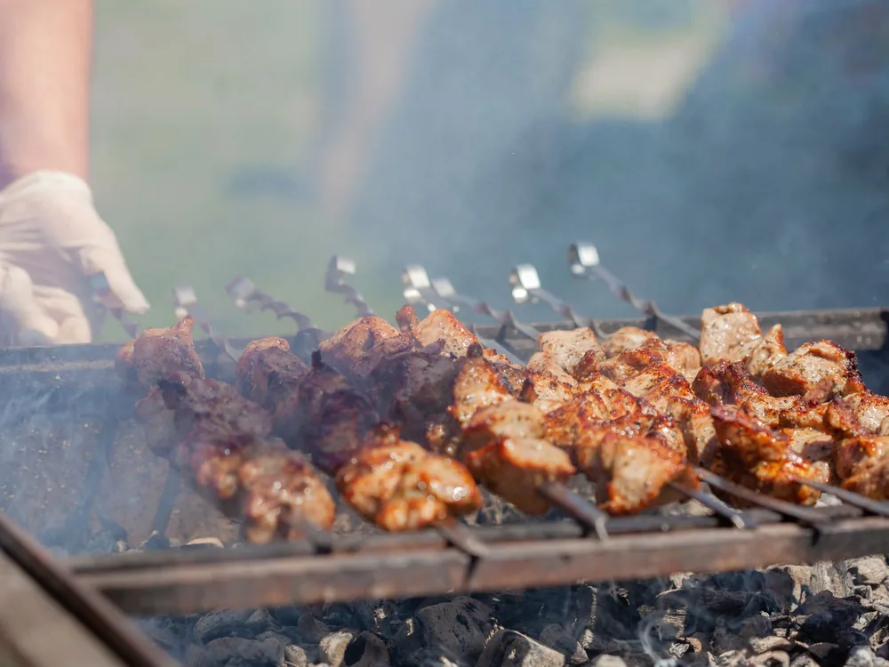 Skewered meat grilling over hot coals